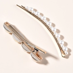 Lot de barrettes à cheveux dorées avec perles blanches élégantes sur fond neutre