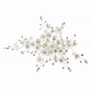 Close-up of bridal hair comb with handmade white flowers, pearls and shiny crystals