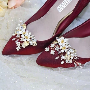 Gros plan de clips de chaussures fleur avec perles et cristaux sur talons bordeaux