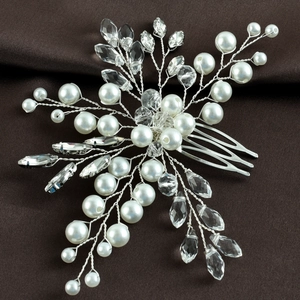Macro detail of bridal hair comb with emerald green crystals and white pearls