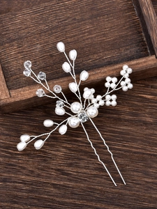 Handmade bridal U-shaped hair pin with pearls and crystals on vintage wood background