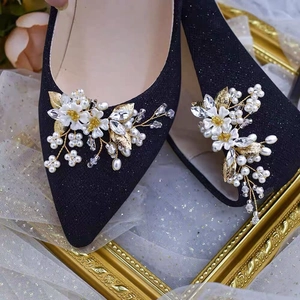 Détail d'un clip chaussure fleur en perles et cristaux sur un escarpin noir élégant