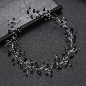 Detailed view of silver wire hair vine with hand-twisted black faceted crystals on dark background