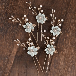 Detailed view of handmade mint green fabric flower hair pins with pearls and gold leaves