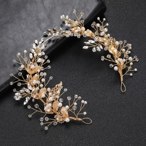 Golden bridal hair pin with handcrafted pearls, crystals and leaf details on black background
