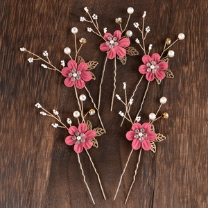 Detailed set of five pink floral hairpins with rhinestones and pearls on wood