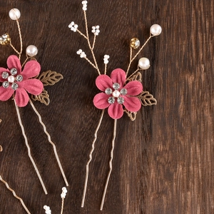 Detailed macro view of pink fabric flowers and white pearls on bridal hair pins
