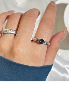 Detail of luxury rings with purple round zircon stone and vintage textured silver bands