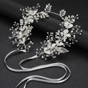 Close-up of handmade bridal hairpiece with pearls, crystals and silver leaf details