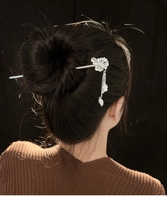 Vue arrière d'un pic à cheveux floral argenté avec pampilles de feuilles sur fond noir