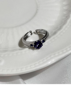 Detail of vintage silver ring with purple round gemstone and engraved textured band