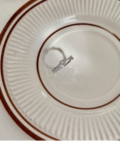 Close-up of heart-shaped open ring with pavé-set stones on a ceramic plate