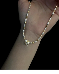 Dettaglio del ciondolo a stella bicolore con texture pizzo e zircone trasparente lucido