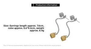 Detail showing two-tone square long tassel drop earrings with intricate carving patterns