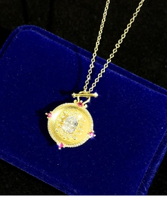Detail of vintage gold mirror pendant with floral diamond border and red gemstones