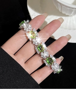 Détails macro des cristaux vert émeraude et zircons sur un bracelet de luxe