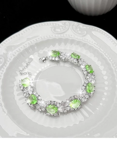 Bracelet en argent avec des pierres précieuses vertes ovales et détails floraux en zircon