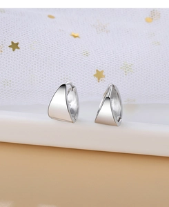 Vue macro de boucles d'oreilles triangulaires en argent avec finition miroir polie