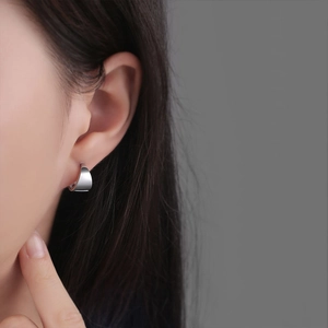 Boucles d'oreilles créoles géométriques en argent poli avec un design minimaliste incurvé