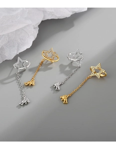 Detail of star and bear tassel earrings in gold and silver finish with micro-inlaid zircon