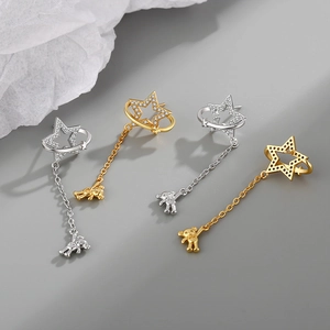 Star earrings with bear charms in gold and silver finish on elegant grey background
