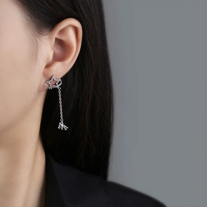 Star-shaped silver stud earring with long fringe chain and 3D astronaut pendant