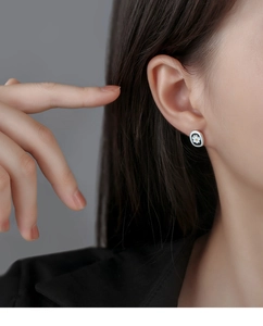 Detailed close-up of small daisy stud earrings on model for a minimalist floral look