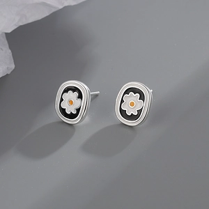 Exquisite floral stud earrings with black oval frames and delicate white flower details