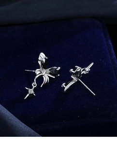 Detail of silver asymmetrical earrings with black butterfly stone and zircon star pendant