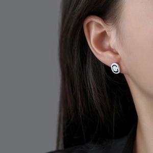 Minimalist daisy flower stud earrings with white petals on black enamel background