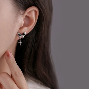 Elegant black butterfly stud earrings with star cross pendant worn by model