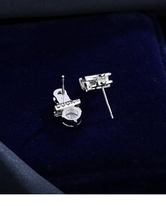 Close-up of silver stud earring with inlaid stone and LUCKY engraving in velvet box
