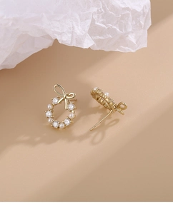 Detail view of bow wreath earrings with small pearls and cubic zirconia stones