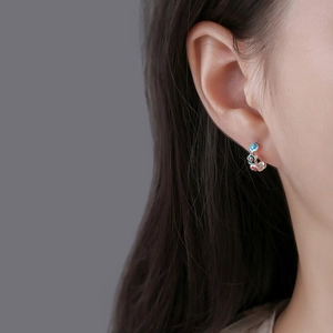 Colorful enamel flower hoop earrings in silver minimalist C-shaped design on model