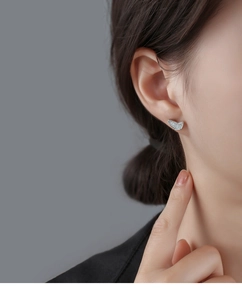 Close-up of asymmetrical butterfly stud earrings with pavé set cubic zirconia