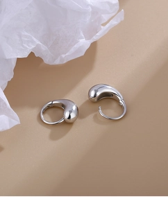 Close-up of polished S925 silver teardrop earrings showing high-gloss finish and hallmark