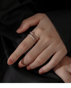 Detail of a minimalist silver double-layer geometric open ring on a finger
