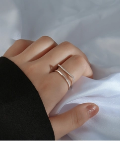 Close-up of a double-layer square geometric silver ring worn on a model's finger