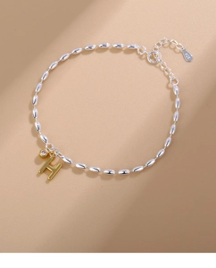 Close-up of S925 sterling silver beaded bracelet with gold H letter and zircon charm
