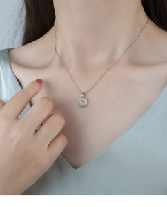 Detailed view of silver necklace featuring square yellow crystal pendant with pavé halo