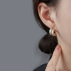 Elegant gold C-shaped hoop earrings with double row baguette zircon stones on model