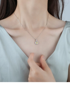 Detailed close-up of a luxury yellow crystal square pendant on a silver necklace