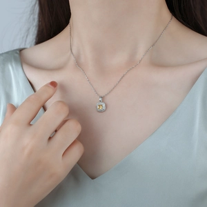 Elegant silver necklace with square yellow crystal pendant on model's neckline