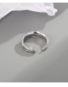 Macro shot of silver adjustable ring with unique irregular liquid metal texture and waves