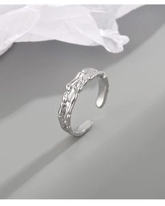Detail of silver irregular liquid metal ring with lava texture on minimalist background