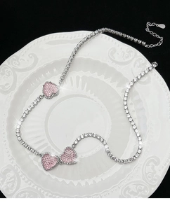 Detail der silbernen S925-Halskette mit drei rosa Herzanhängern und weißen Kristallen