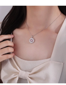Gros plan du pendentif fleur avec zircon rose central et pétales en zircons blancs