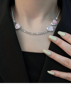 Nahaufnahme der rosa Herzanhänger mit Pavé-Kristallen an einer silbernen Tenniskette