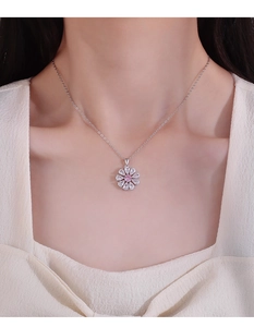 Gros plan du collier avec pendentif fleur rose et cristal sur un mannequin femme