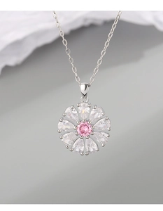 Gros plan d'un pendentif marguerite en argent avec zircon rose et pétales en cristal